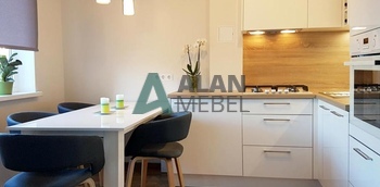 стильная белая угловая кухня с пластиковыми фасадами и столешницей под дерево