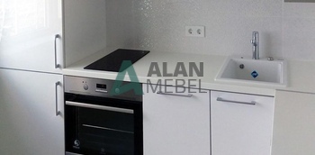 маленькая угловая кухня с белыми матовыми фасадами и белой столешницей на заказ