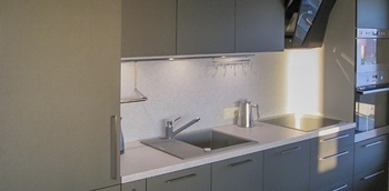 прямая кухня с матовыми фасадами серого цвета и столешницей из постформинга