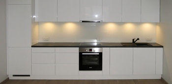 прямолинейная кухня белого цвета с глянцевыми фасадами без ручек