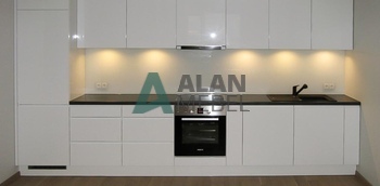 прямолинейная кухня белого цвета с глянцевыми фасадами без ручек