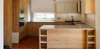 большая встроенная кухня под дерево светлого цвета в частный дом