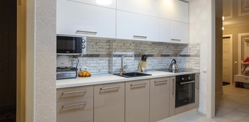 прямая встроенная кухня с глянцевыми фасадами в светлых оттенках