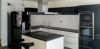 большая черно-белая кухня с глянцевыми фасадами и островом на заказ