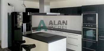 большая черно-белая кухня с глянцевыми фасадами и островом на заказ