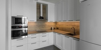 Кухня угловая с фасадами из натурального дерева, под потолок, столешница с еврозапилом