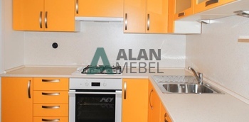 угловая кухня с матовыми фасадами из пластика оранжевого цвета и светлой столешницей на заказ