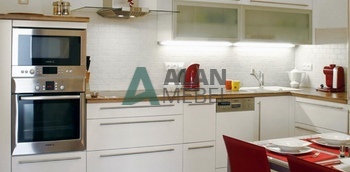 стильная большая кухня с матовыми фасадами белого цвета и столешницей под дерево