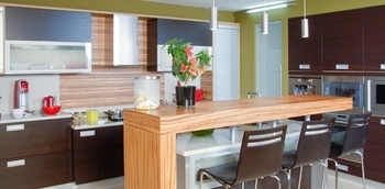 кухня в дом с фасадами из МДФ со шпоном темного оттенка и барной стойкой на заказ