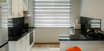 белая кухня с рамочными фасадами из МДФ со шпоном ясеня и столешницей под черный камень