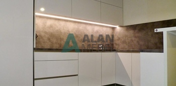 Кухня современная п-образная без ручек белого цвета со встроенной техникой