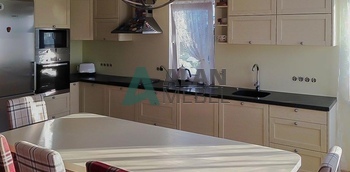 кухня угловая молочного цвета с матовыми рамочными фасадами и черной столешницей на заказ