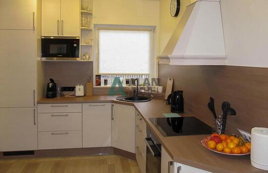 большая Г-образная кухня с матовыми фасадами светлого цвета с мойкой под окно в частный дом 