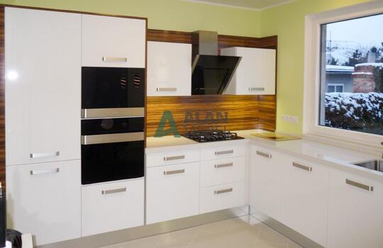 Стильная кухня под окно с глянцевыми фасадами белого цвета на заказ 