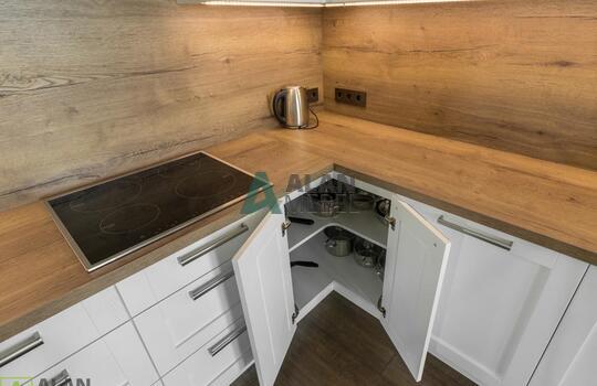 Кухня угловая с фасадами из натурального дерева, под потолок, столешница с еврозапилом 