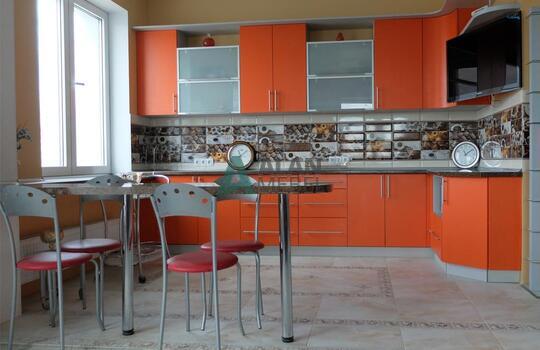 большая Г-образная кухня оранжевого цвета с темной столешницей под заказ по индивидуальным размерам 