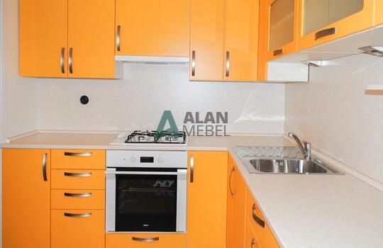 угловая кухня с матовыми фасадами из пластика оранжевого цвета и светлой столешницей на заказ 