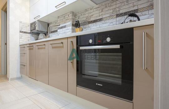 прямая встроенная кухня с глянцевыми фасадами в светлых оттенках 