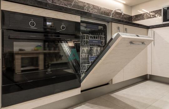 современная п-образная кухня из шпона ясеня бежевого цвета с черной глянцевой столешницей 