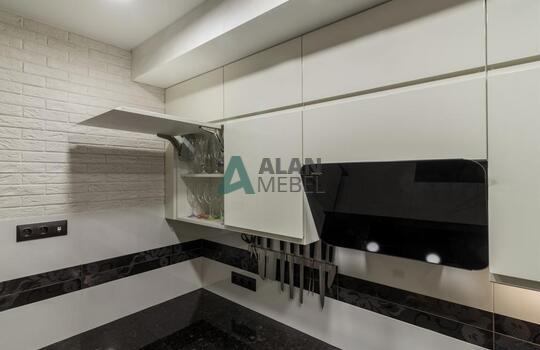 современная п-образная кухня из шпона ясеня бежевого цвета с черной глянцевой столешницей 