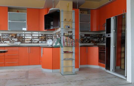 большая Г-образная кухня оранжевого цвета с темной столешницей под заказ по индивидуальным размерам 