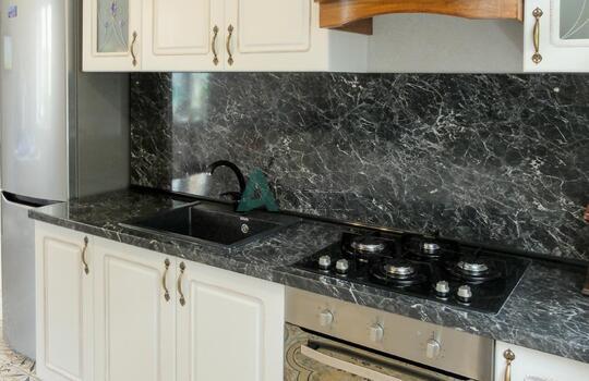 белая кухня с рамочными фасадами из МДФ со шпоном ясеня и столешницей под черный камень 