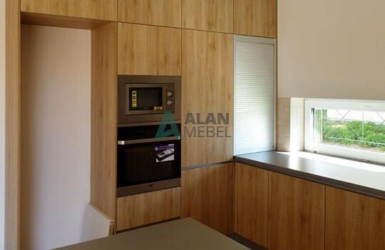 большая встроенная кухня под дерево светлого цвета в частный дом 