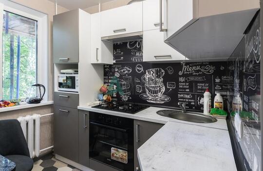 Современная строгая кухня с фасадами из древесно стружечной плиты в серо-белых тонах 