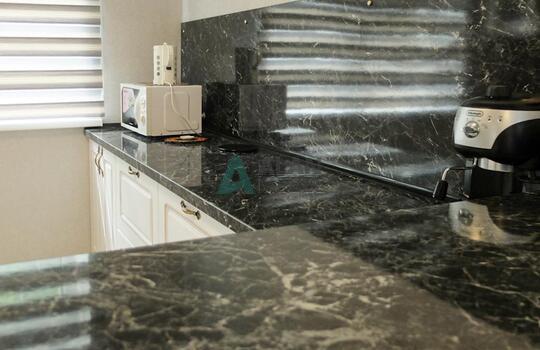 белая кухня с рамочными фасадами из МДФ со шпоном ясеня и столешницей под черный камень 