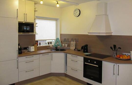 большая Г-образная кухня с матовыми фасадами светлого цвета с мойкой под окно в частный дом 