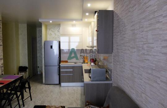 маленькая Г-образная кухня с глянцевыми фасадами белого цвета верх и серого цвета низ без ручек 