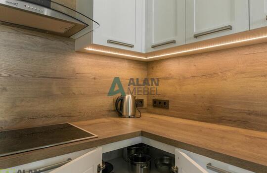 Кухня угловая с фасадами из натурального дерева, под потолок, столешница с еврозапилом 