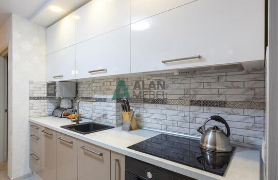 прямая встроенная кухня с глянцевыми фасадами в светлых оттенках 