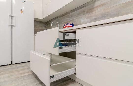 Угловая светлая кухня с матовыми фасадами из МДФ, без ручек 