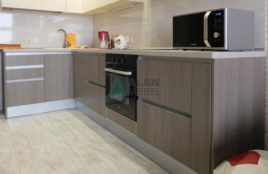 маленькая Г-образная кухня с глянцевыми фасадами белого цвета верх и серого цвета низ без ручек 