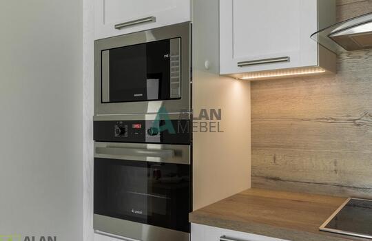 Кухня угловая с фасадами из натурального дерева, под потолок, столешница с еврозапилом 