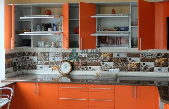 большая Г-образная кухня оранжевого цвета с темной столешницей под заказ по индивидуальным размерам 