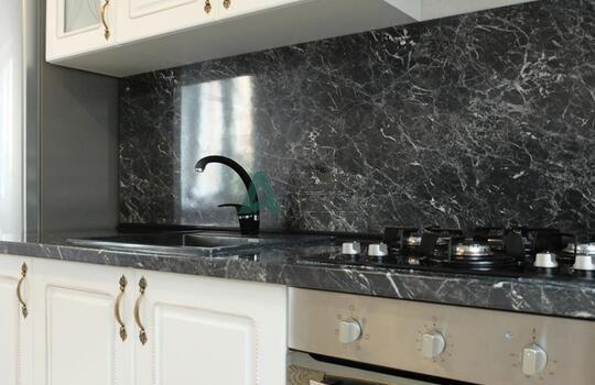 белая кухня с рамочными фасадами из МДФ со шпоном ясеня и столешницей под черный камень 