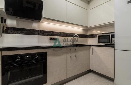 современная п-образная кухня из шпона ясеня бежевого цвета с черной глянцевой столешницей 