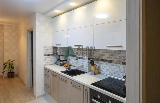 прямая встроенная кухня с глянцевыми фасадами в светлых оттенках 