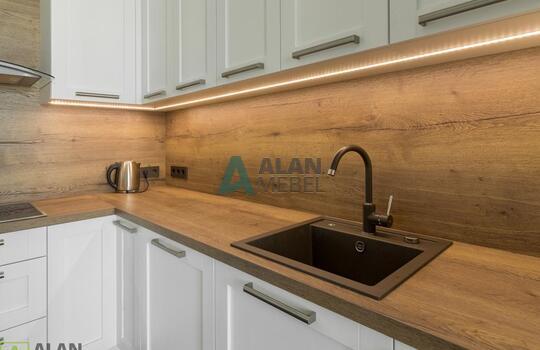 Кухня угловая с фасадами из натурального дерева, под потолок, столешница с еврозапилом 