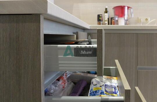 маленькая Г-образная кухня с глянцевыми фасадами белого цвета верх и серого цвета низ без ручек 