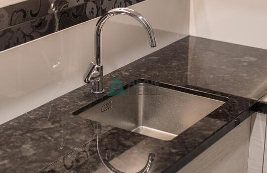 современная п-образная кухня из шпона ясеня бежевого цвета с черной глянцевой столешницей 