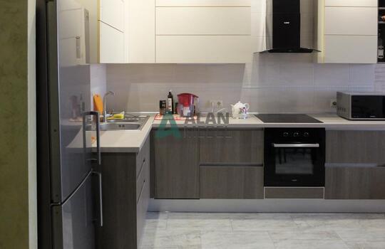 маленькая Г-образная кухня с глянцевыми фасадами белого цвета верх и серого цвета низ без ручек 