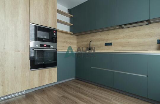 Угловая кухня под дерево с зелеными фасадами из феникса (FENIX) 