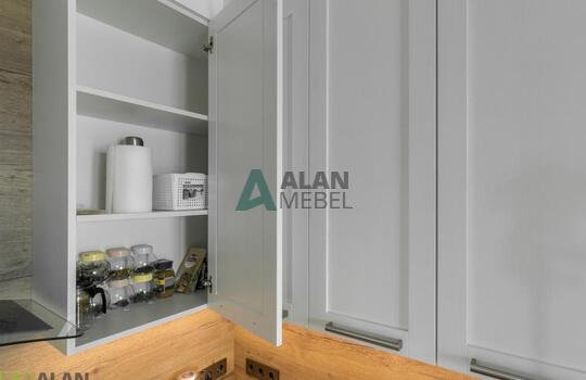 Кухня угловая с фасадами из натурального дерева, под потолок, столешница с еврозапилом 