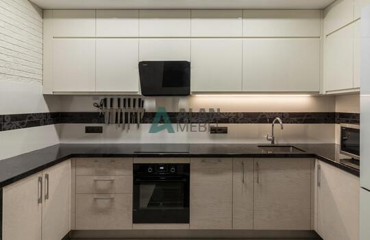 современная п-образная кухня из шпона ясеня бежевого цвета с черной глянцевой столешницей 