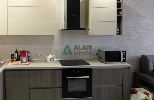 маленькая Г-образная кухня с глянцевыми фасадами белого цвета верх и серого цвета низ без ручек 