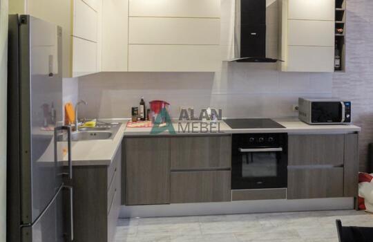 маленькая Г-образная кухня с глянцевыми фасадами белого цвета верх и серого цвета низ без ручек 