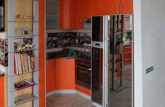 большая Г-образная кухня оранжевого цвета с темной столешницей под заказ по индивидуальным размерам 